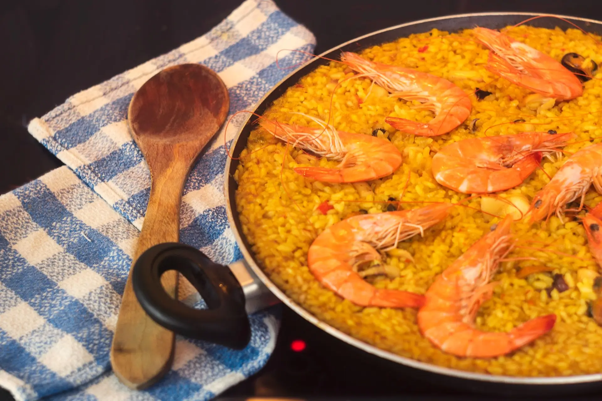 Arroz de gambas en paella con cuchara de madera